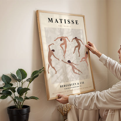 framed artwork featuring a minimalist illustration of dancers inspired by Matisse, light wooden frame and neutral toned background