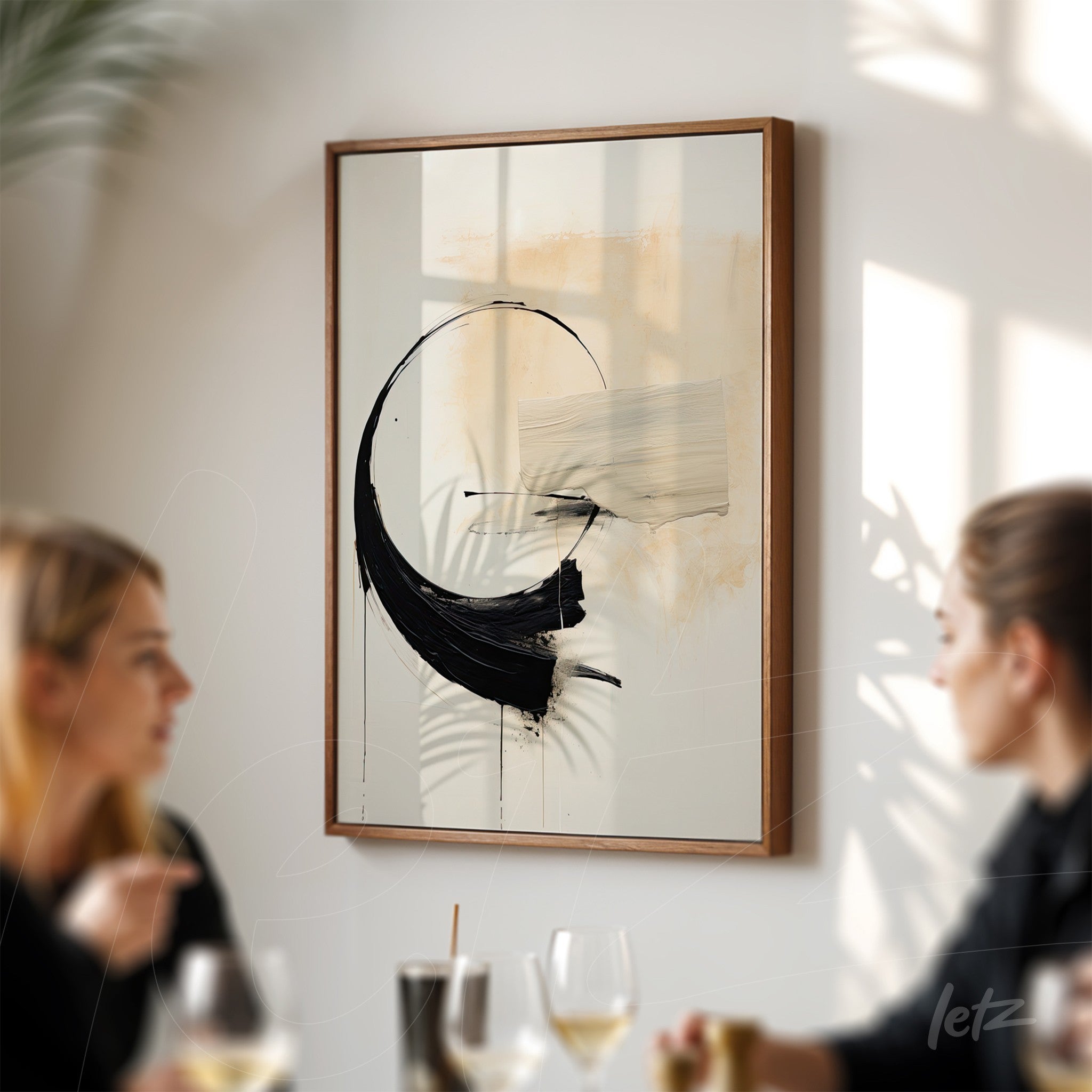 abstract artwork featuring black brush strokes on neutral tones, framed in light wood, displayed on a well-lit wall