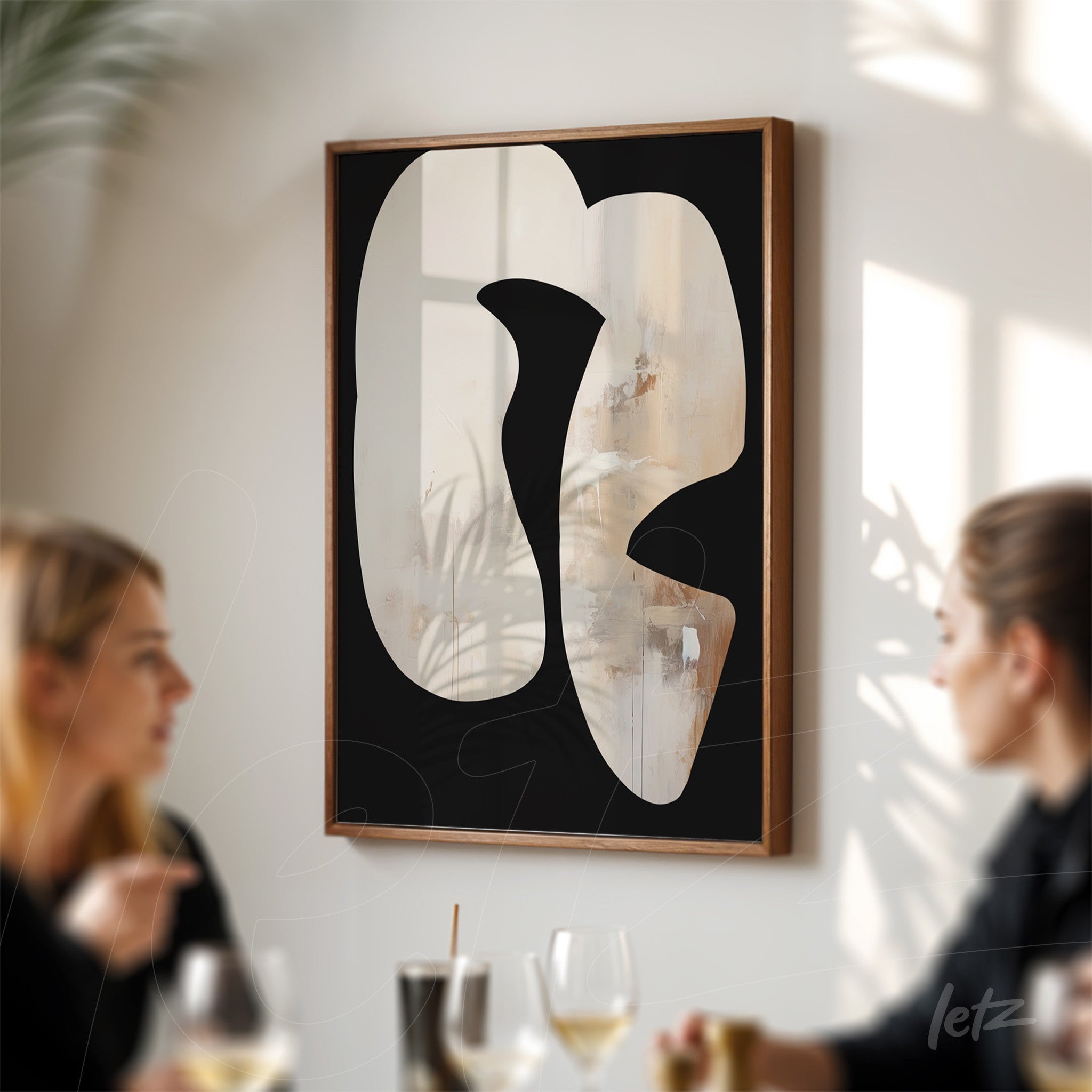 abstract wall art in a light wood frame featuring organic shapes on a black background