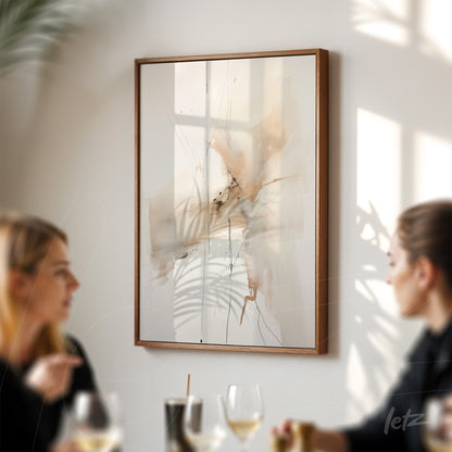 modern artwork with abstract strokes in cream and brown tones framed in dark wood displayed on a wall illuminated by natural light