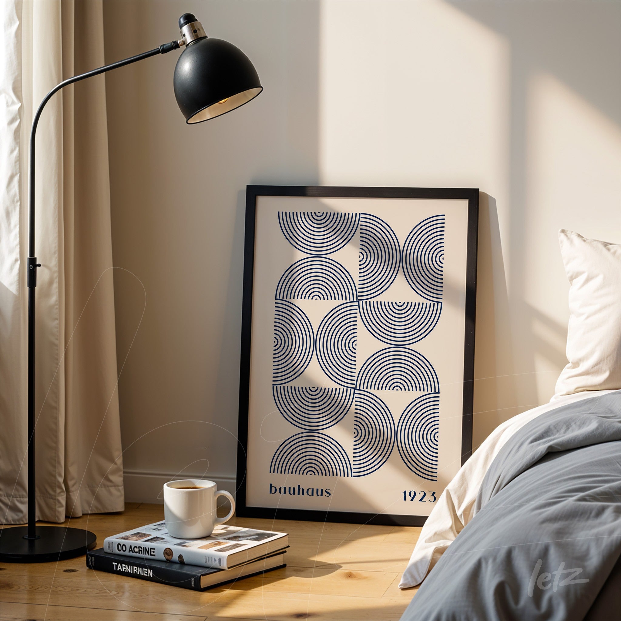 black framed geometric bauhaus style art leaning against the wall next to a bed