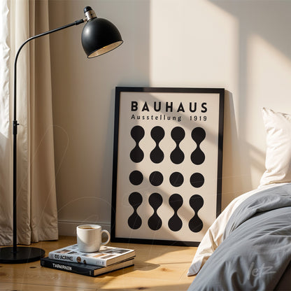 bauhaus style geometric design art leaning against wall next to modern lamp with a cup of coffee and stacked books on the floor
