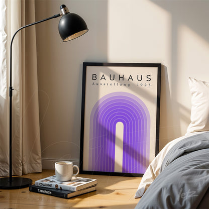 poster print of Bauhaus Ausstellung 1923 with geometric design in black frame, leaning on the floor next to a bed