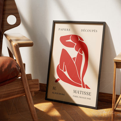 minimalist framed wall art of a red female figure displayed indoors