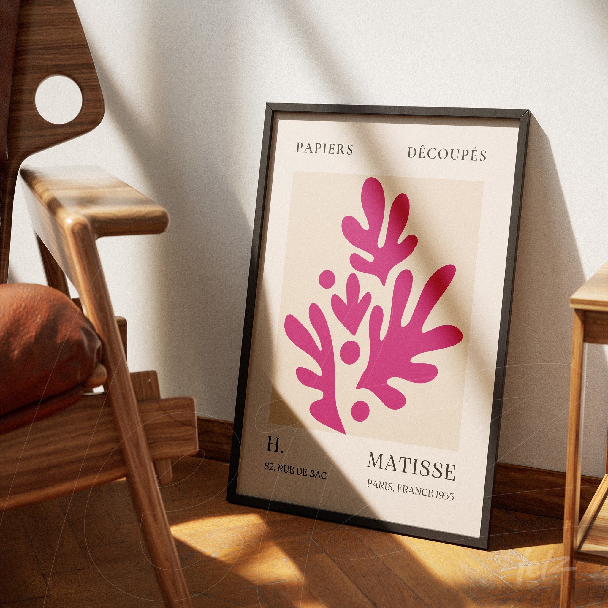 framed wall art featuring modern paper cutouts in black frame, displayed in cozy setting with wooden chair