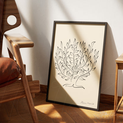 framed artwork featuring minimalist black outline tree design leaning against a wooden chair