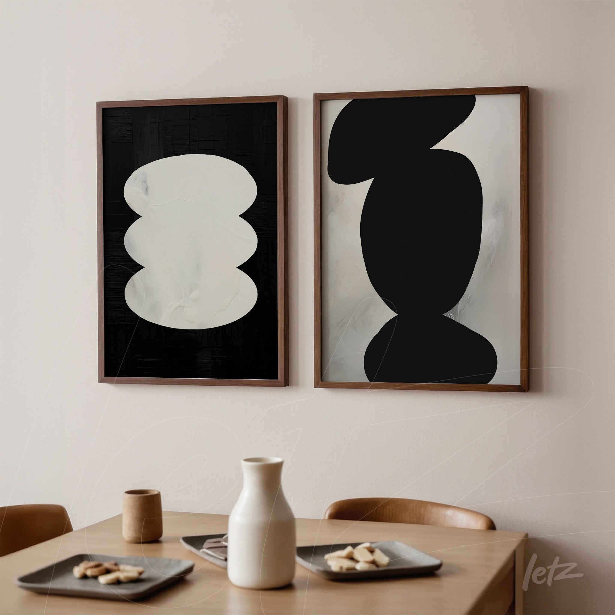 set of framed artworks featuring abstract black and white shapes in light wood frames displayed on a neutral wall