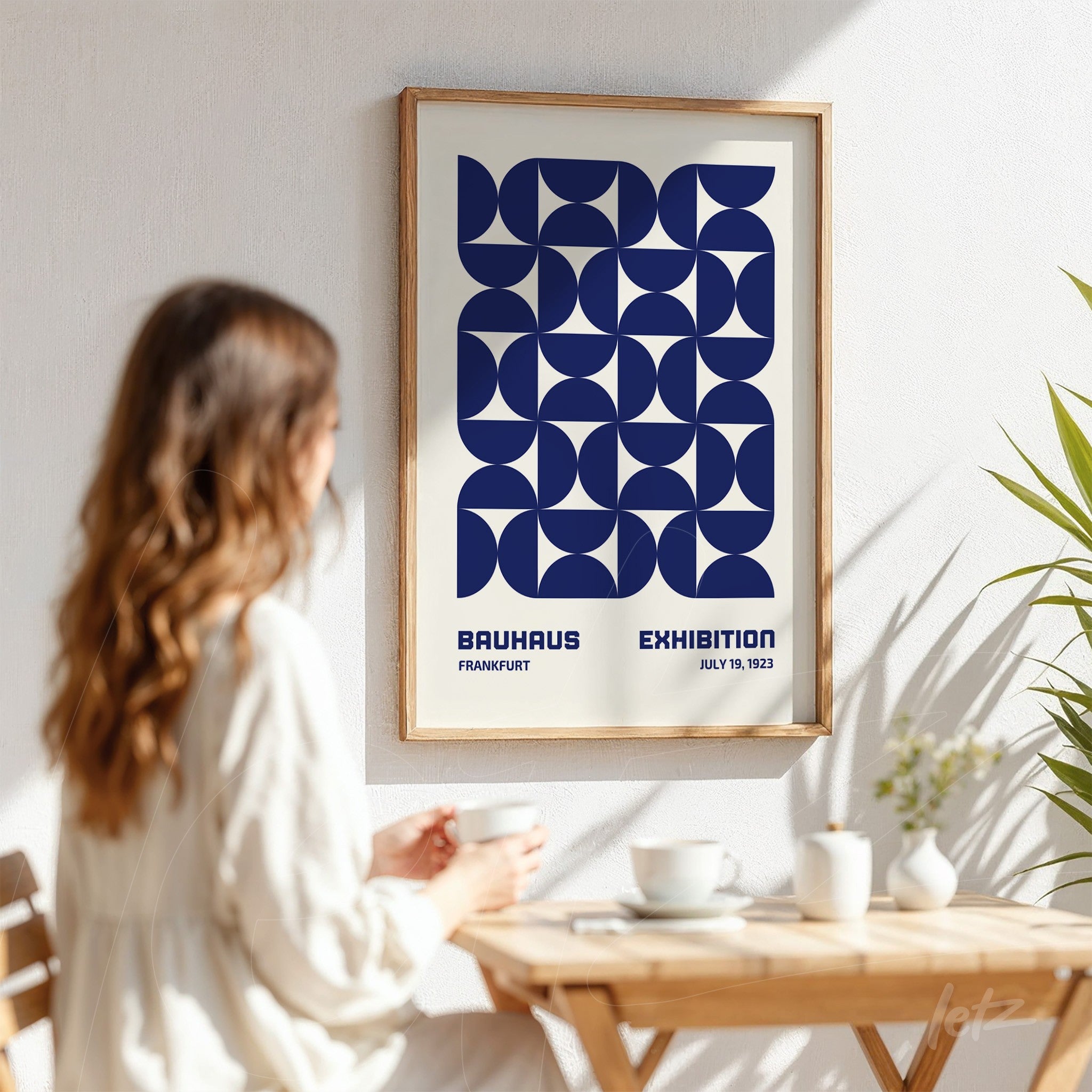 poster featuring geometric bauhaus style design in light frame displayed on white wall