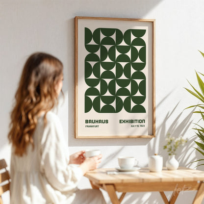 poster of bauhaus exhibition with green geometric patterns in light wooden frame displayed on white wall