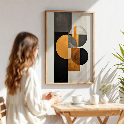 abstract framed art with geometric shapes in black, gold, and white, displayed in a bright room