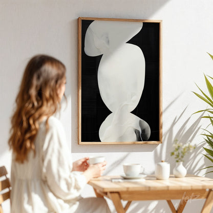 abstract art print featuring fluid white shapes on a black background in a light wooden frame