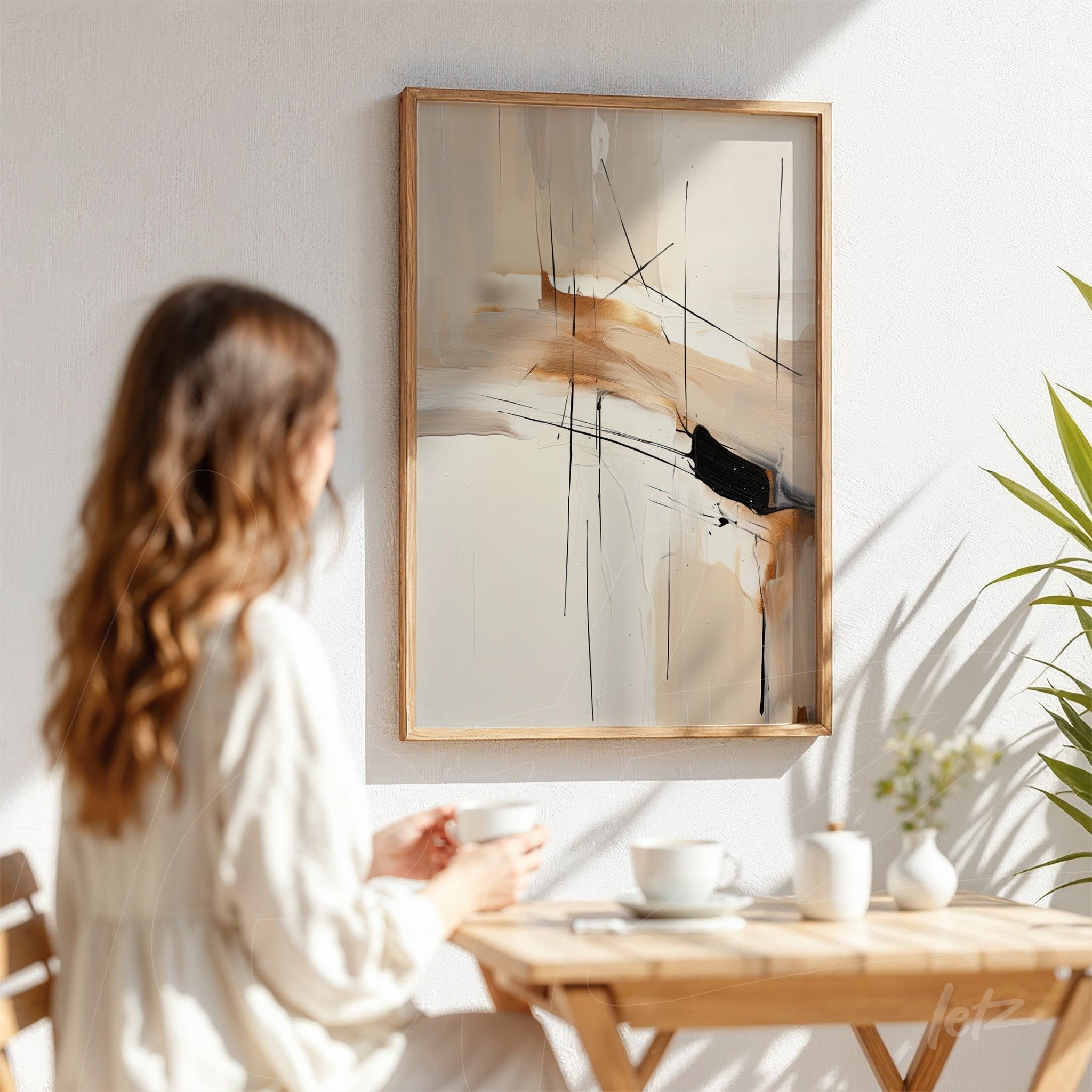 abstract painting in earthy tones with black strokes in light wood frame hanging on white wall