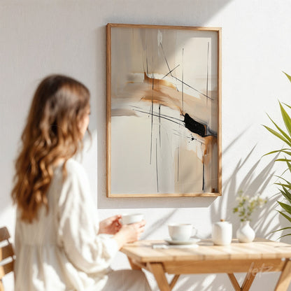 abstract painting in earthy tones with black strokes in light wood frame hanging on white wall