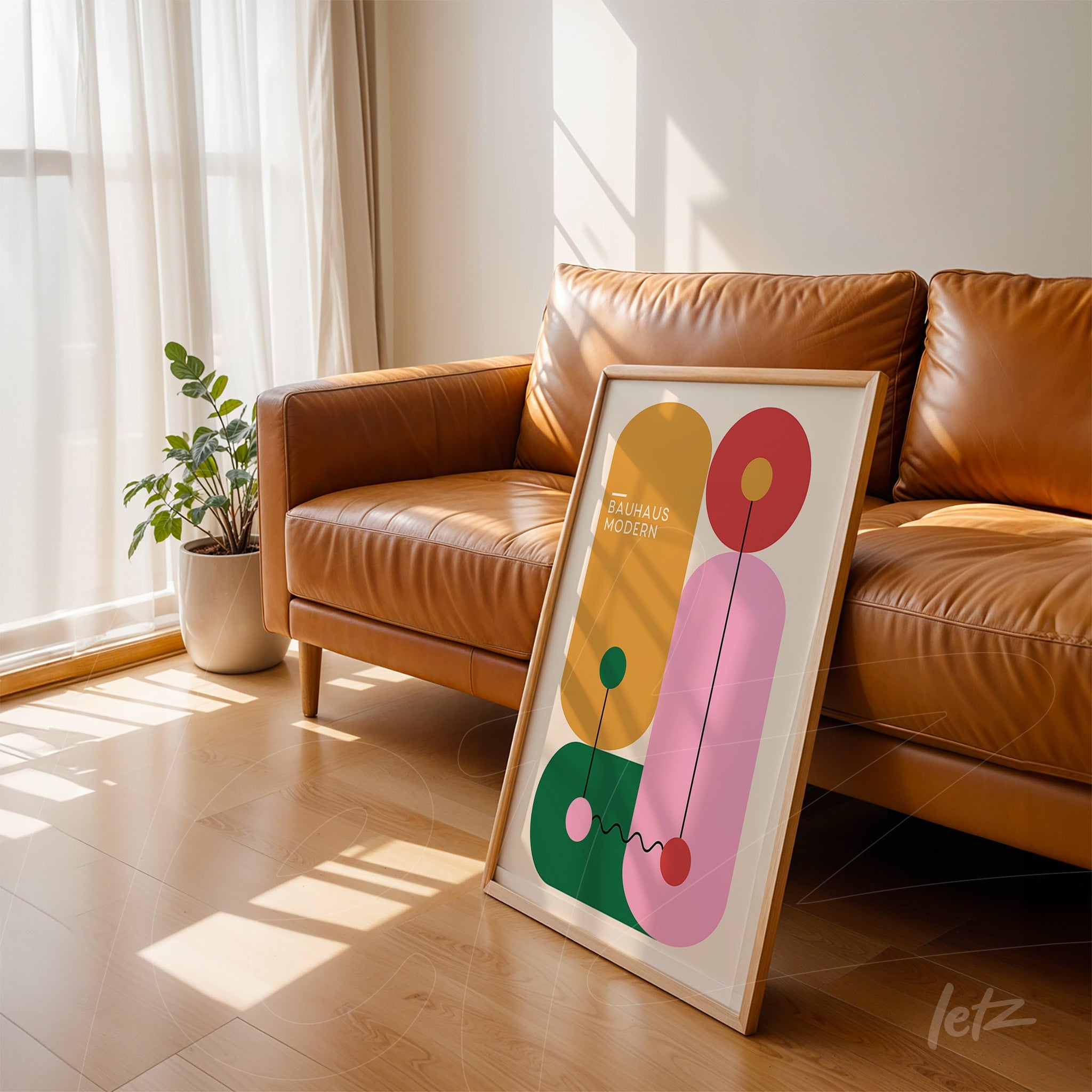 abstract bauhaus style art leaned against a brown leather couch, featuring colorful geometric shapes and a light wood frame