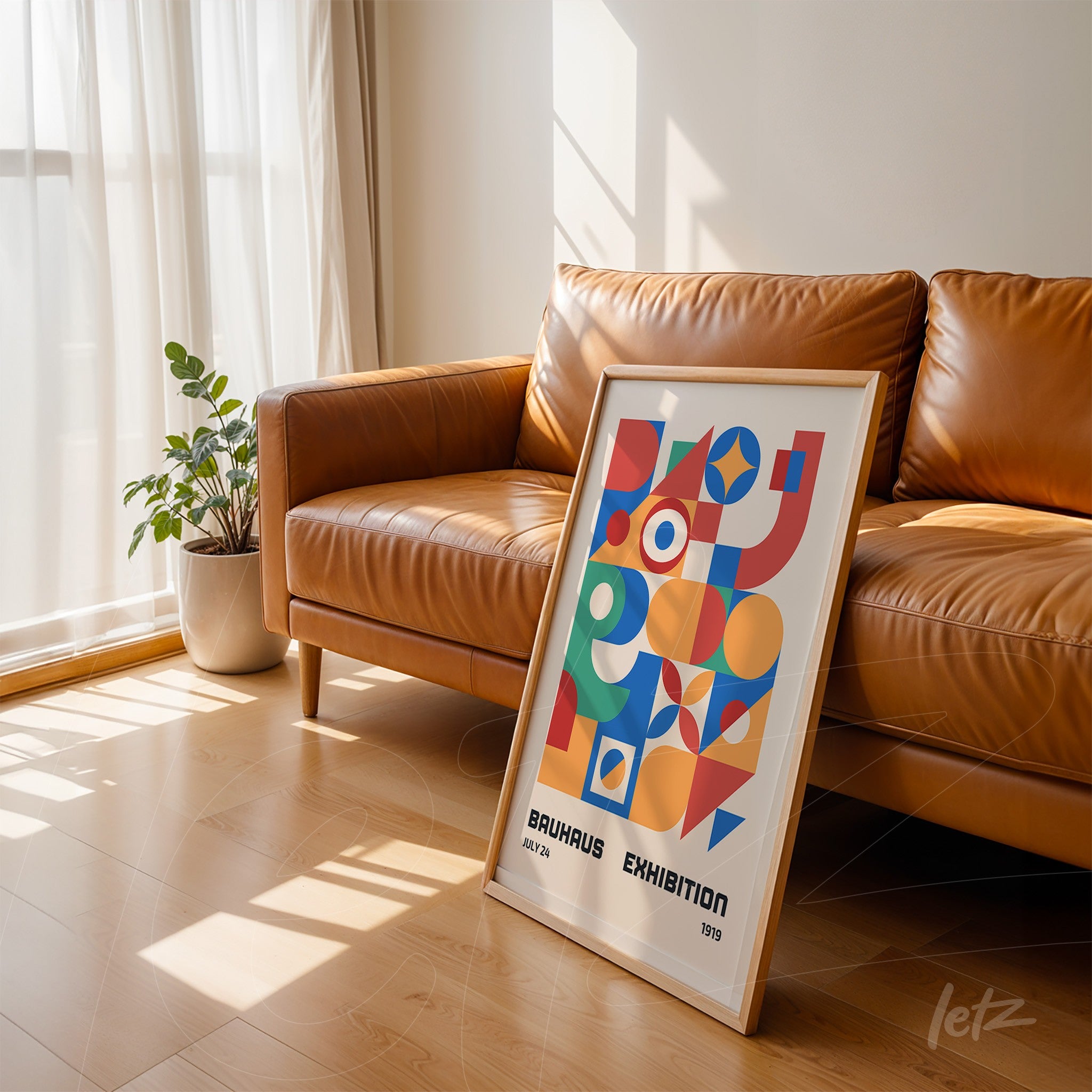 abstract poster in light frame leaning against a leather sofa
