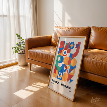 abstract poster in light frame leaning against a leather sofa