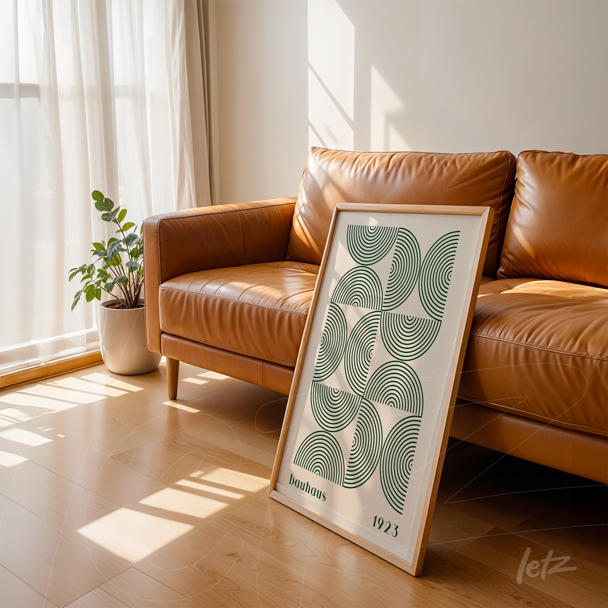 poster print of geometric art with green and black concentric circles leaning against brown sofa with light wooden frame
