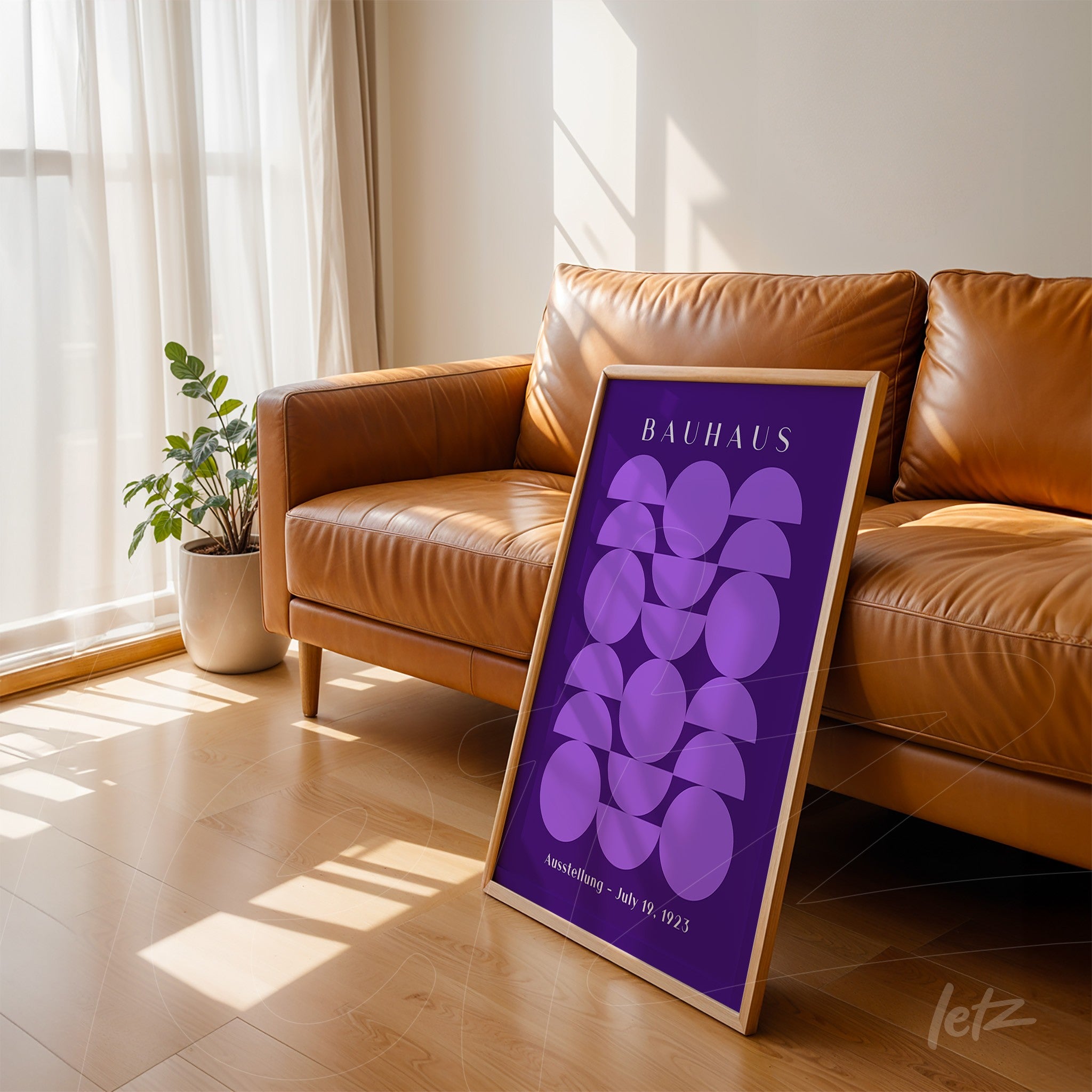 poster featuring lilac geometric shapes in wooden frame, leaning against leather sofa in a well-lit room