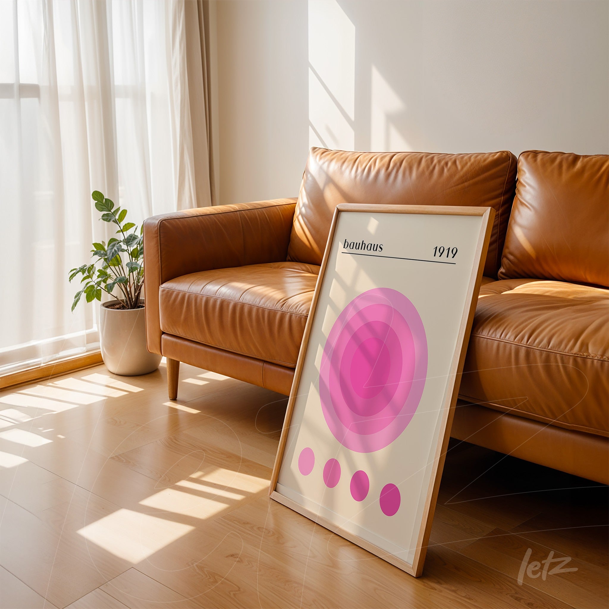 minimalist bauhaus style poster in light wood frame leaning against a brown leather sofa
