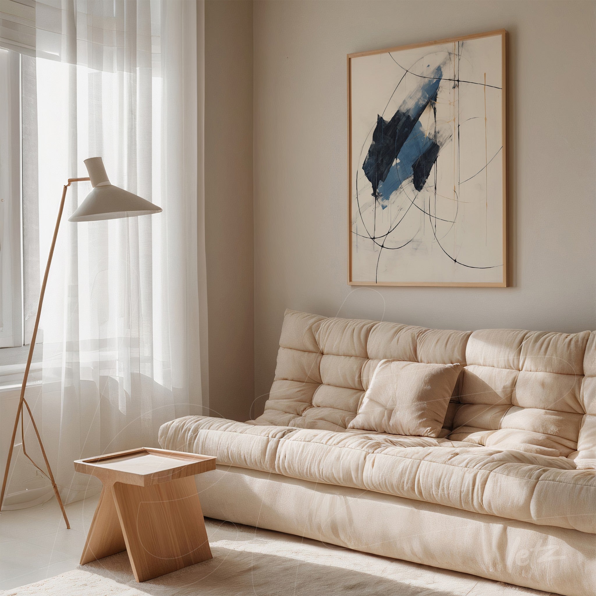abstract wall art in shades of blue with light frame displayed above a beige sofa in a minimalist setting