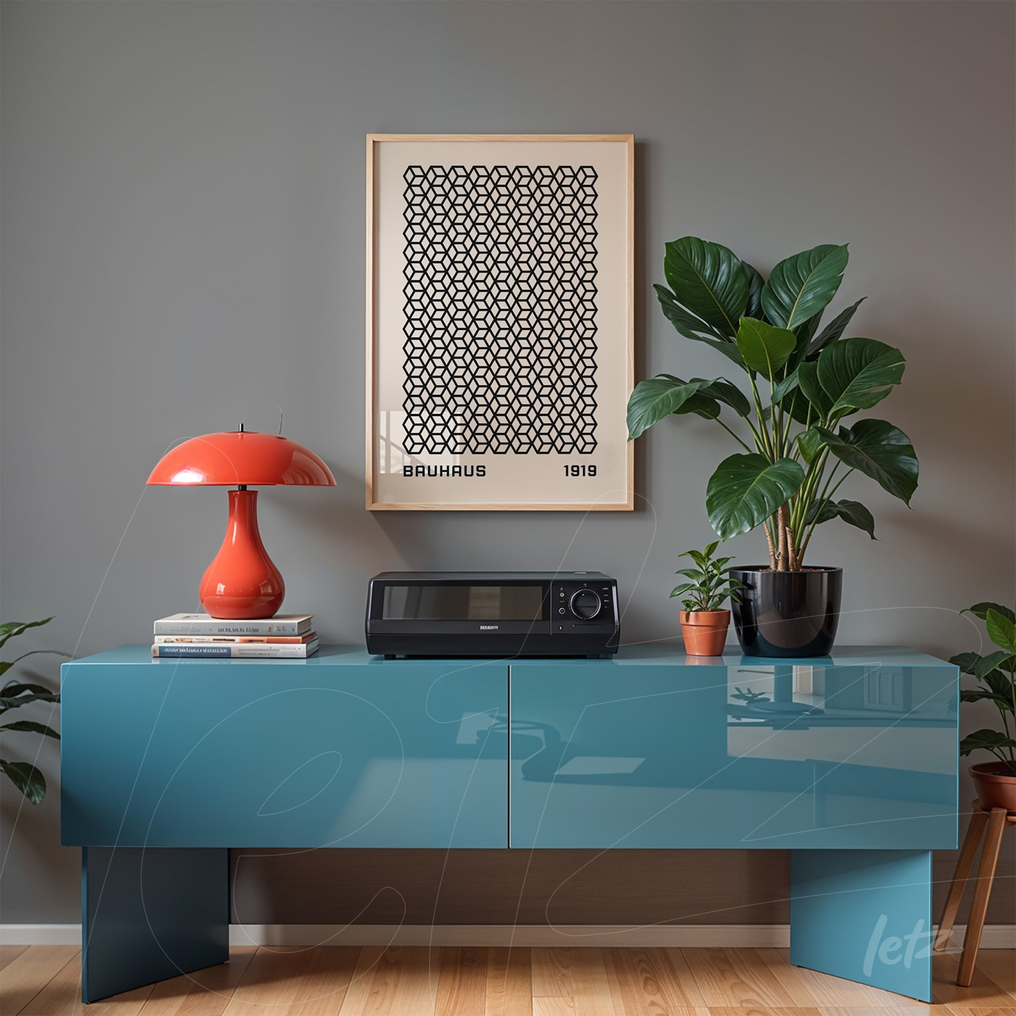 poster with geometric pattern in light wood frame on gray wall, next to modern red lamp and green plants