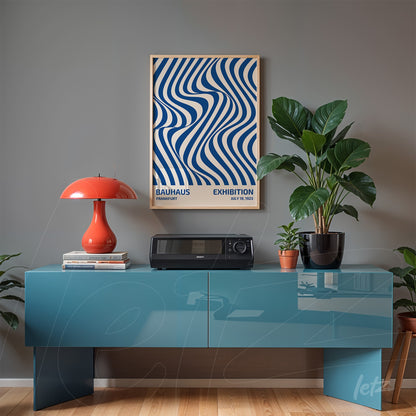 poster featuring blue wavy lines on a beige background, framed in light wood, displayed above a blue sideboard in a decorated setting