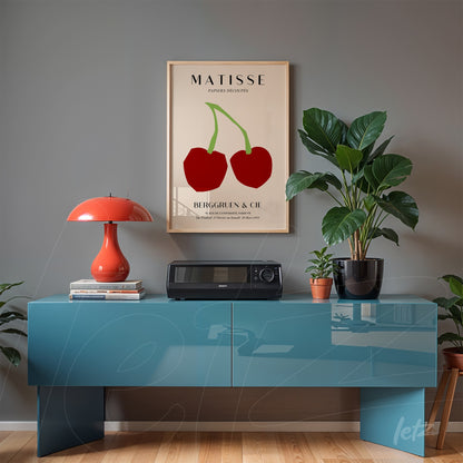 framed wall art by Matisse featuring colorful cherries displayed above a blue console against a gray wall