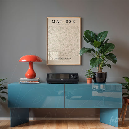 framed botanical art by matisse displayed above a blue cabinet with a plant beside it