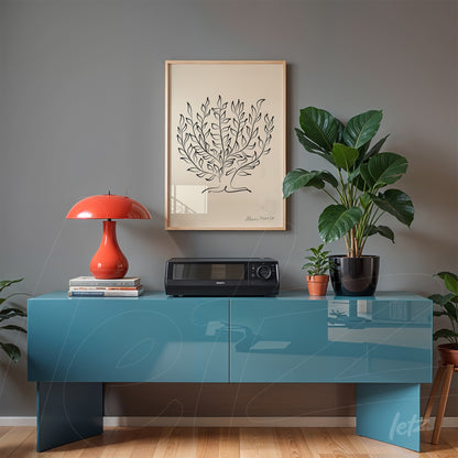 minimalist framed artwork of a palm tree displayed above a blue cabinet with a red lamp and indoor plants