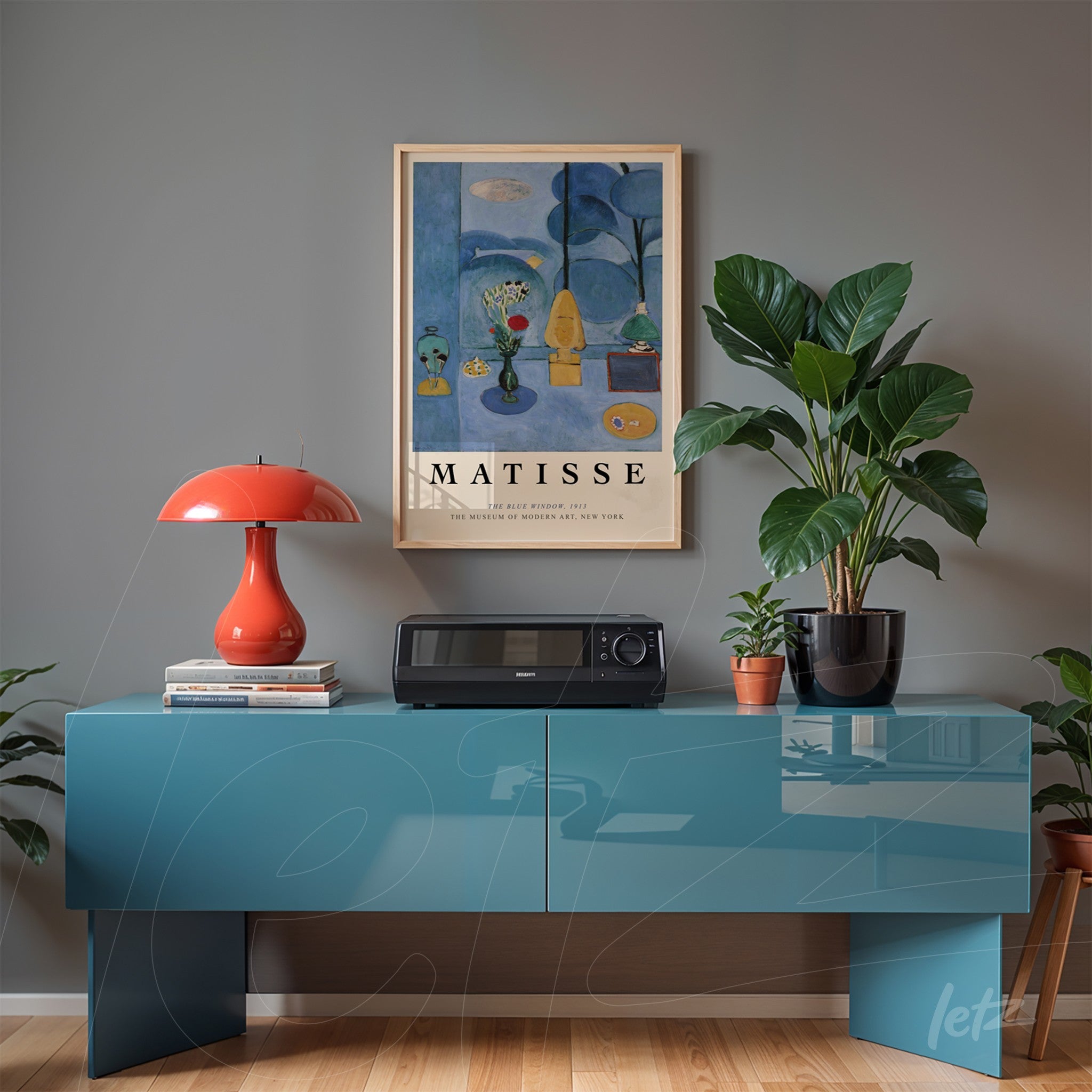framed wall art by Henri Matisse displayed on gray wall, complementing a blue cabinet with a red lamp