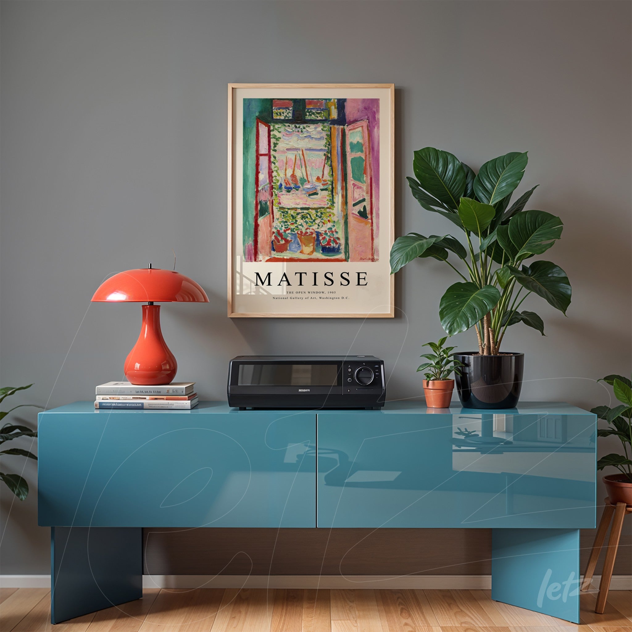 vintage artwork of a landscape by Matisse in a light frame above a blue sideboard, decorated with a red lamp and green plants