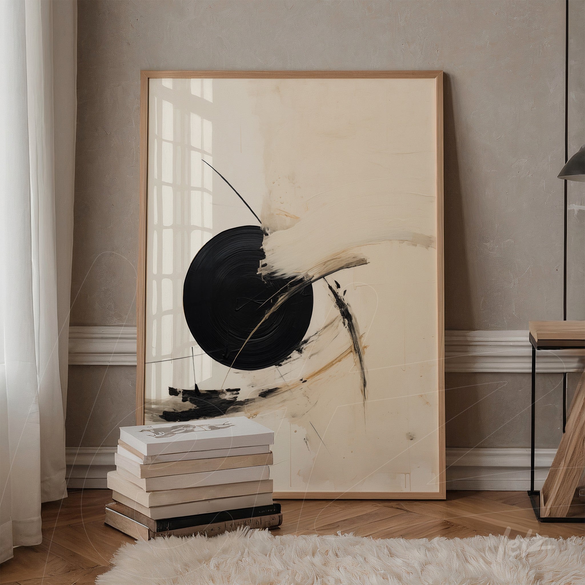 abstract artwork featuring a black circle on cream background with light wood frame, leaning on shelf next to a stack of books