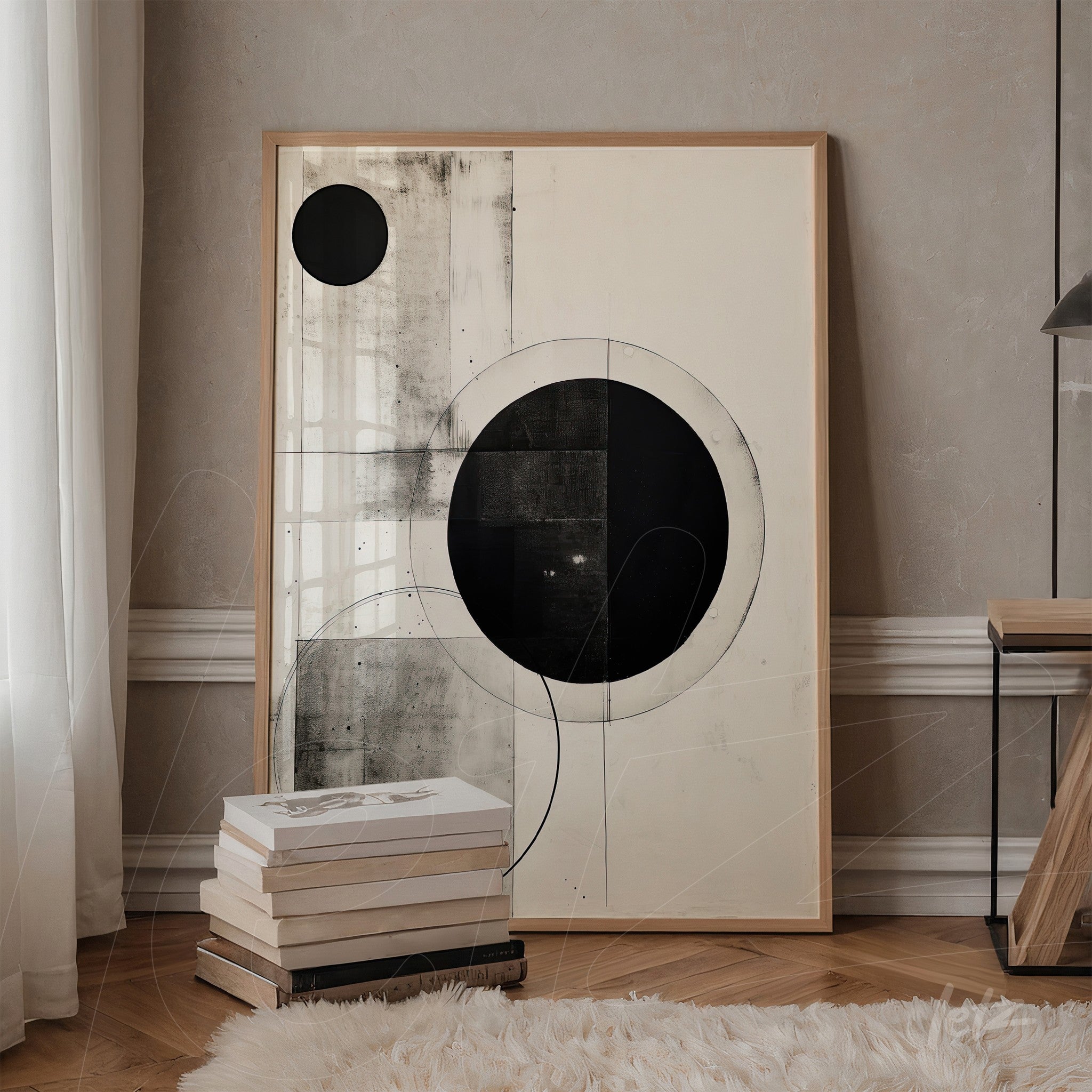abstract wall art in black and white featuring geometric shapes, light wood frame, leaning against a light wall next to a stack of books