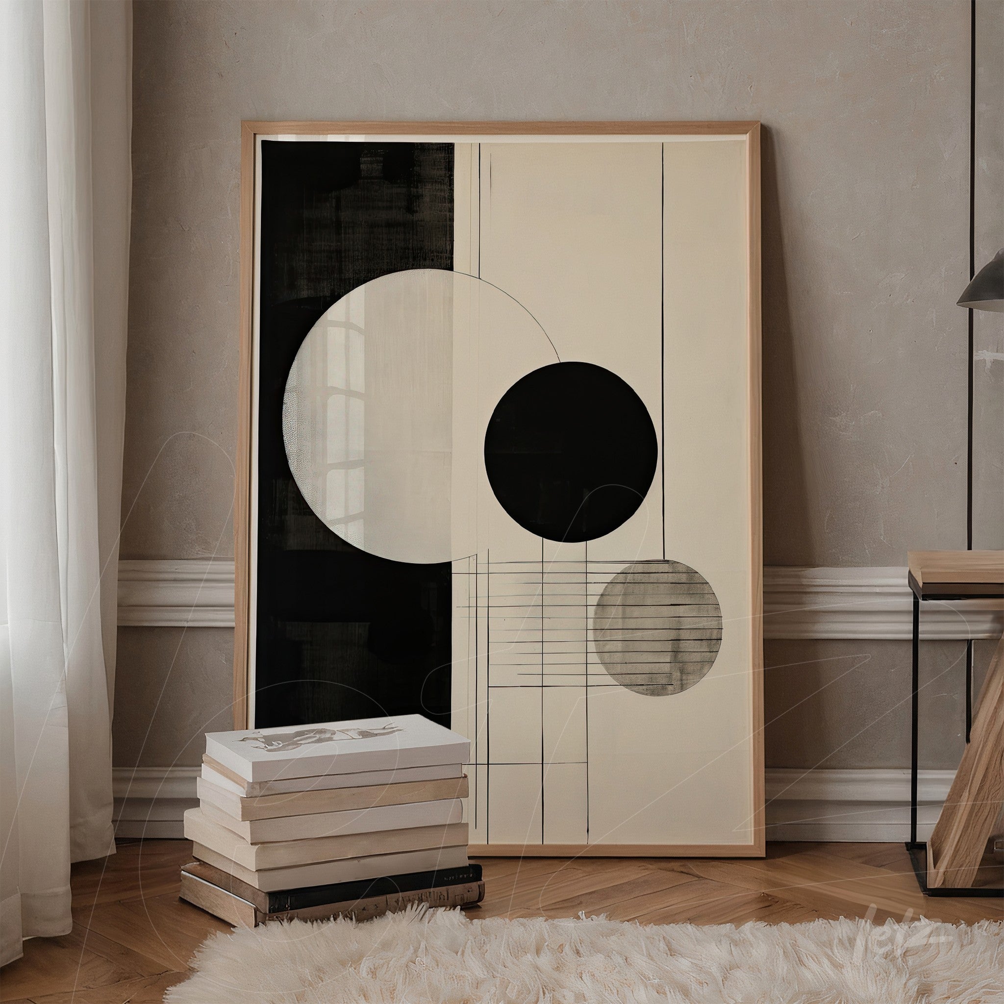 framed abstract wall art in black and white with light wood frame displayed next to a stack of books in a stylish setting