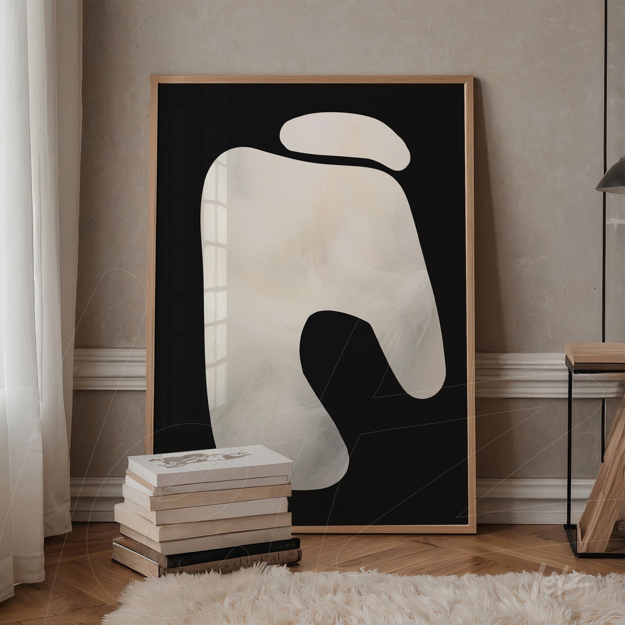 abstract wall art in light wood frame featuring soft white shapes on a black background