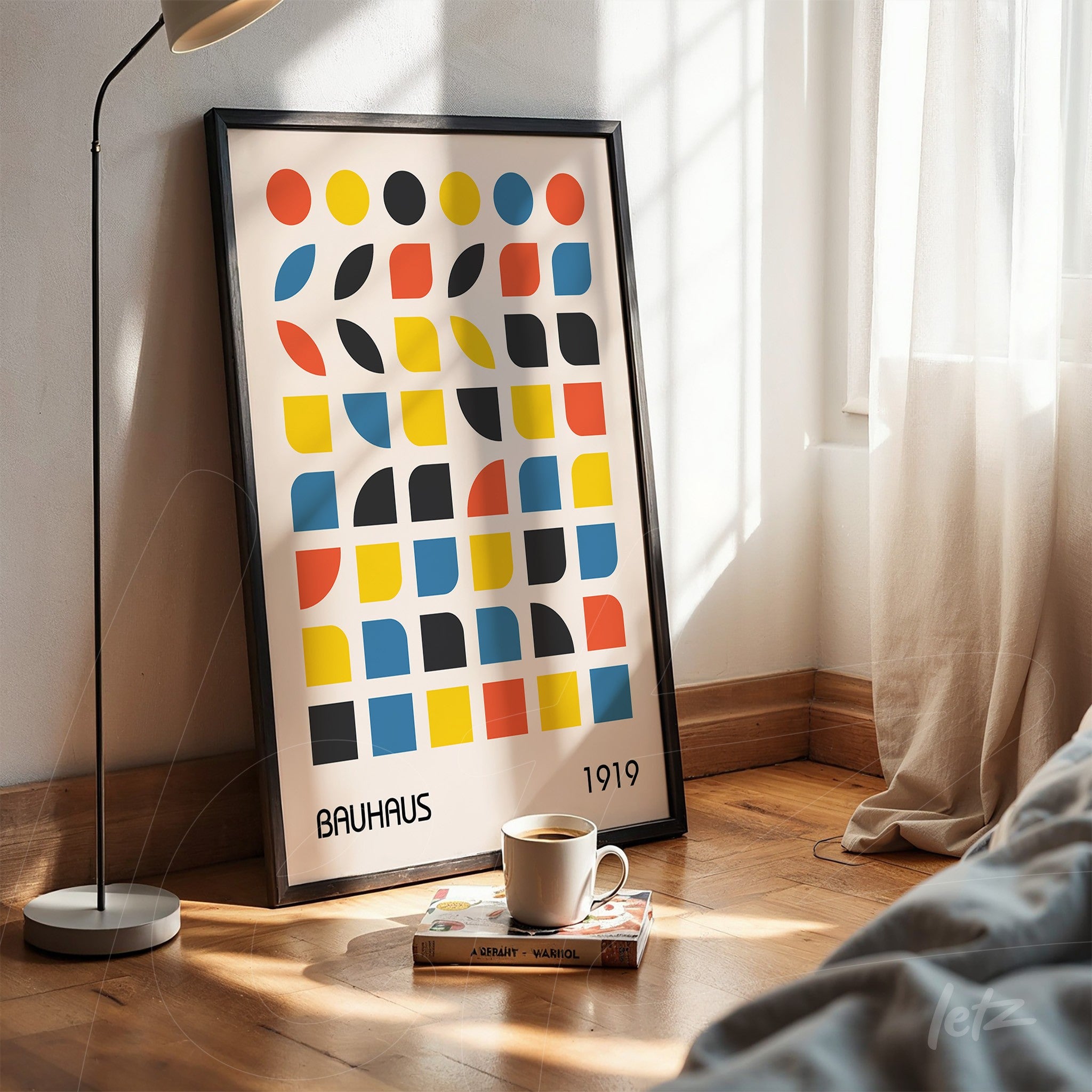 poster featuring bauhaus style geometric art in black frame leaning on wooden floor