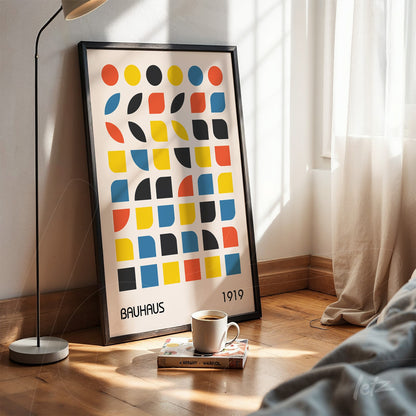 poster featuring bauhaus style geometric art in black frame leaning on wooden floor