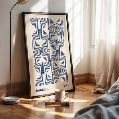 poster print featuring bauhaus geometric design in black frame resting on wooden floor