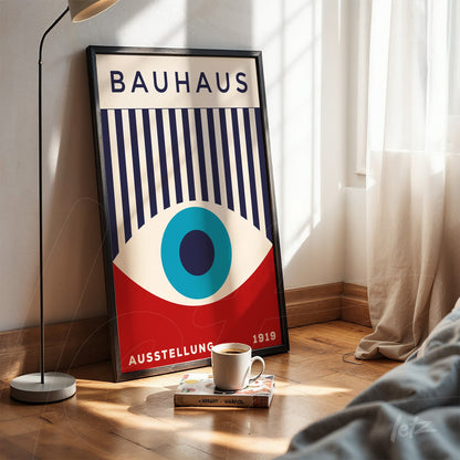 poster print featuring a geometric Bauhaus style design in a black frame on a wooden floor next to a coffee cup