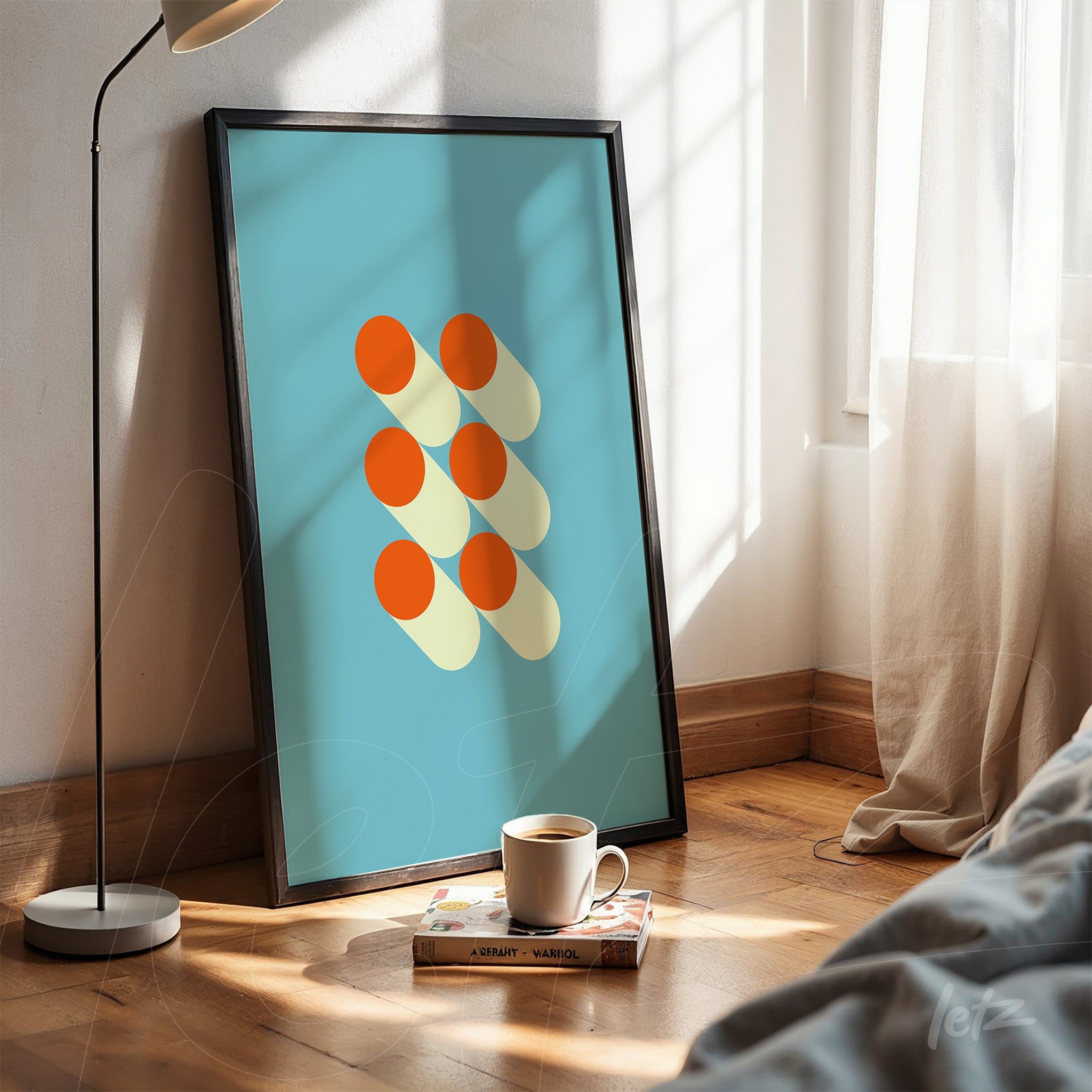 poster with geometric art of orange circles and shadows on a blue background in a black frame, resting on the floor illuminated by natural light