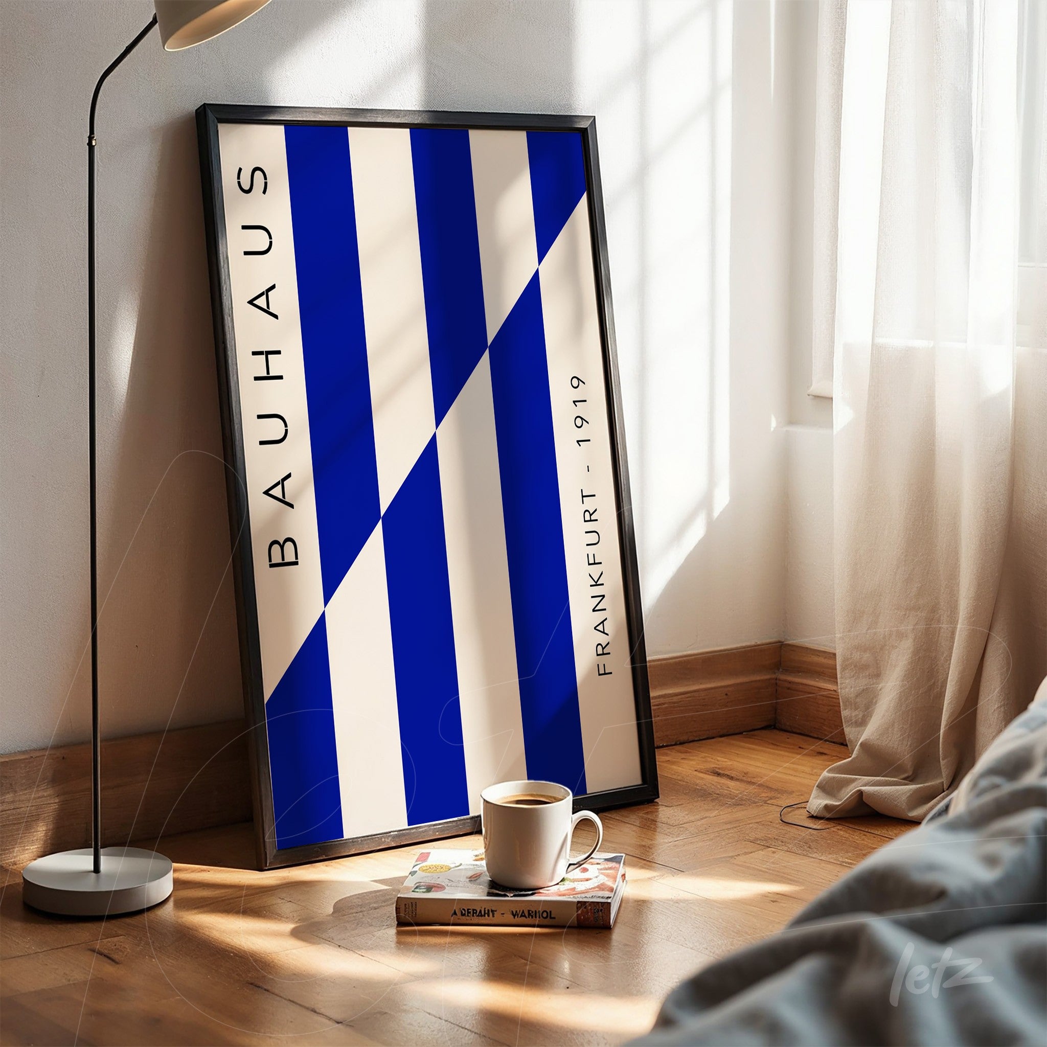 bauhaus style poster in blue and white tones with black frame resting on wooden floor
