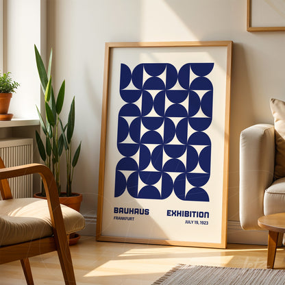 poster print of geometric Bauhaus style art with light wood frame, displayed on a rug in a sunlit room