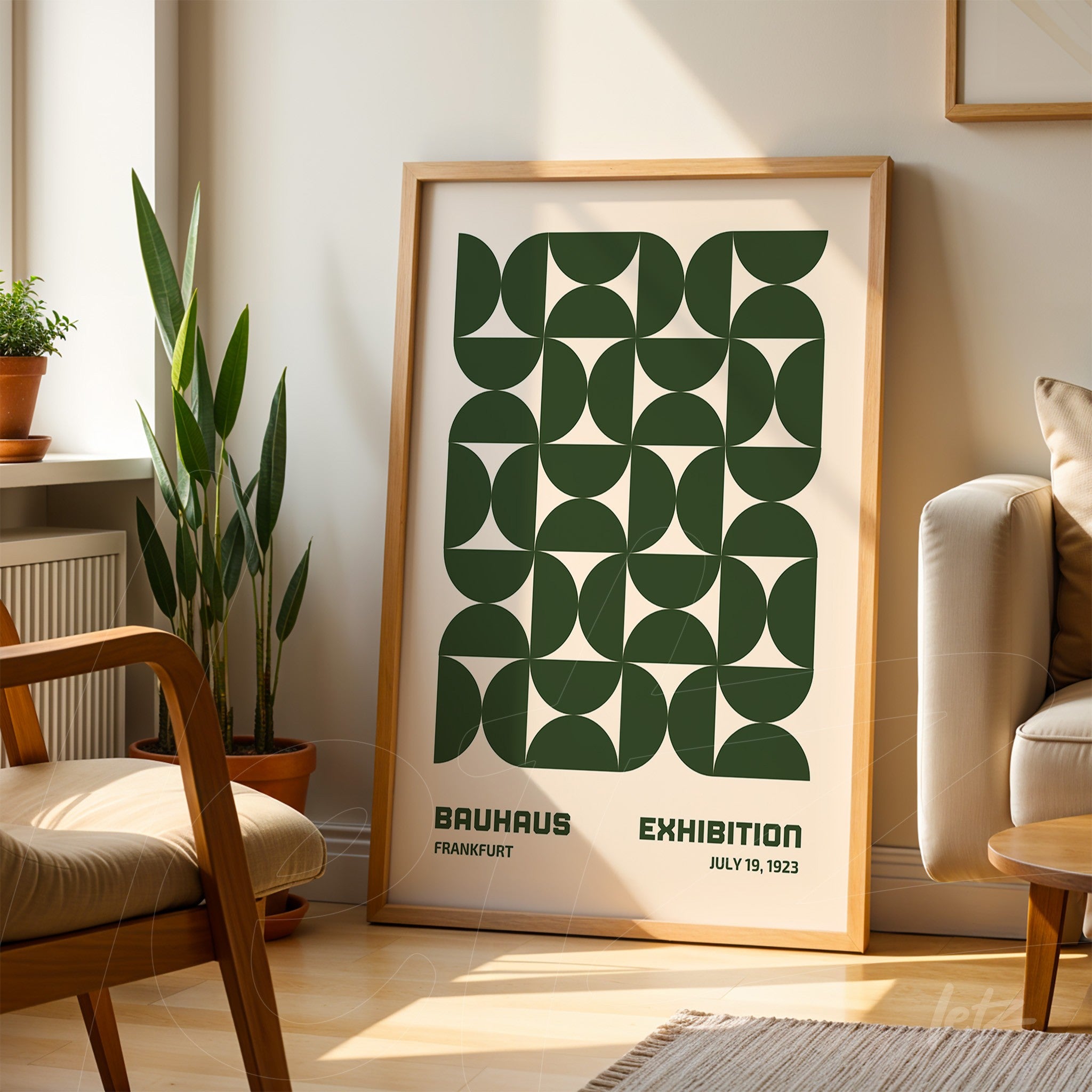 poster print with green geometric design framed in light wood, leaning against a wall in a naturally lit living room