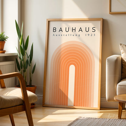 poster print with geometric design in orange tones and light wooden frame resting in a modern living room