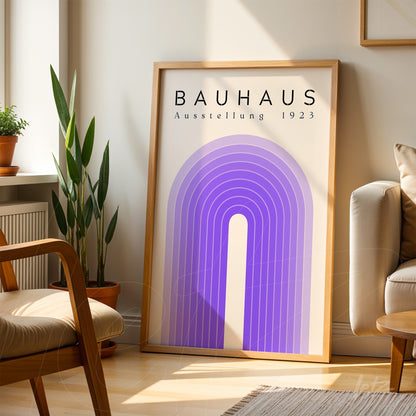 framed poster featuring a geometric rainbow design in shades of lilac with the text bauhaus ausstellung 1923, set in a bright room with a wooden frame