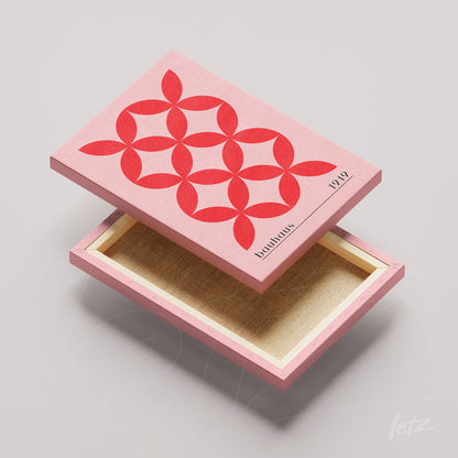 open pink gift box with lid showing red geometric pattern