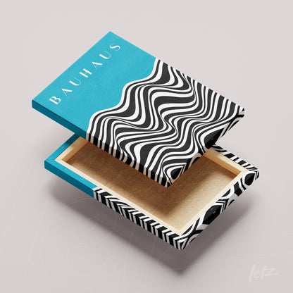 bauhaus style canvas art with black and white patterns and blue side on light gray background