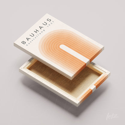 canvas print with geometric bauhaus style art in orange tones and text displayed on light surface