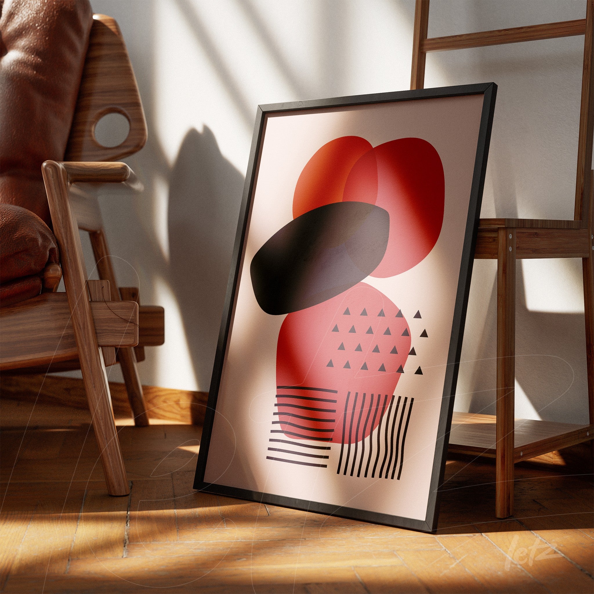 framed abstract art with geometric shapes in red and black tones leaning on wooden floor