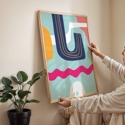 ```json
{
  "alt": "quadro boho com formas geométricas em cores modernas, exibido em moldura de madeira clara sendo segurado por uma pessoa ao lado de uma planta",
  "alt_en": "boho wall art with geometric shapes in modern colors, displayed in a light wooden frame held by a person next to a plant"
}
```